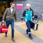 foto voor spoedpost Deventer: Huisarts en Ambulance chauffeur met medische tassen op weg naar patient